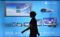 Женщина проходит мимо рекламного щита операционной системы Windows 10 в Сеуле, Южная Корея