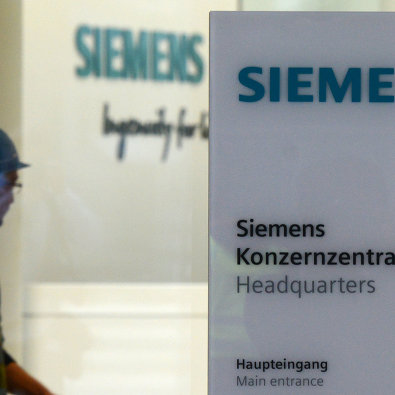 Рабочий у входа в штаб-квартиру компании Siemens в Мюнхене, Германия