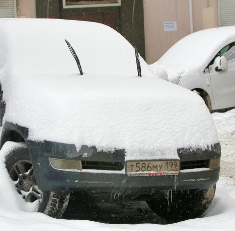 Снег на припаркованных автомобилях в Москве
