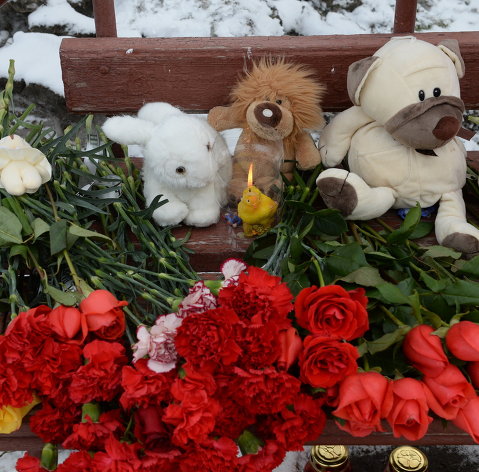 Цветы, свечи и мягкие игрушки возле здания торгового центра «Зимняя вишня» в Кемерово, где произошел пожар