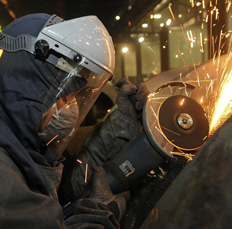 Рабочий во время обработки изделий на сталелитейном производстве.
