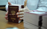 Сотрудница ФГУП "Гознак" упаковывает для отправки готовые биометрические заграничные паспорта граждан РФ в Резервном центре персонализации в Москве