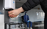 Рабочий пользуется антисептиком перед началом смены на заводе "Метровагонмаш" в подмосковных Мытищах