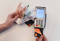 Терминал оплаты банковскими картами и денежные купюры.