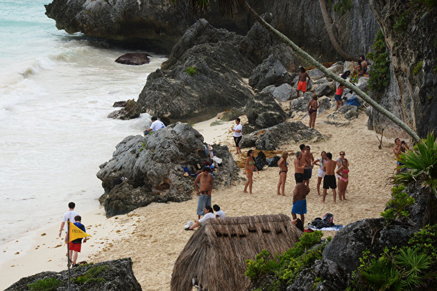 Туристы на пляже в окрестностях доколумбового города Тулум цивилизации майя в Мексике