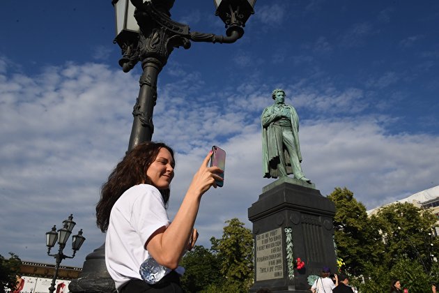 Девушка со смартфоном на Пушкинской площади в Москве