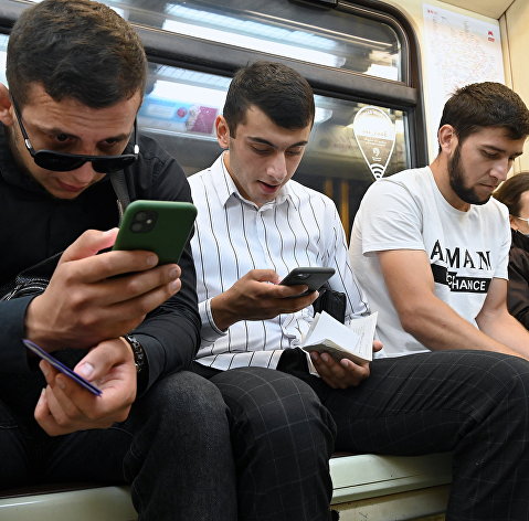 Мужчины со смартфонами в вагоне московского метро