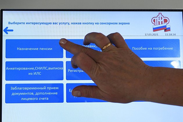 Человек выбирает услугу в терминале в ПФР в Москве.