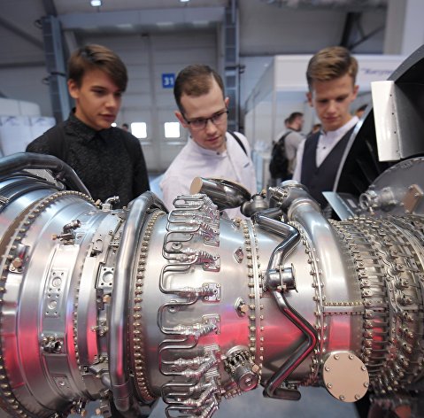 Посетители рассматривают газовую турбину на международной промышленной выставке Посетители рассматривают газовую турбину на международной промышленной выставке