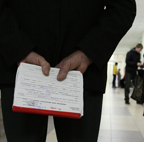Мужчина держит в руках медицинскую карточку