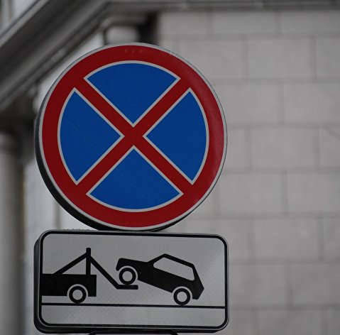 Дорожные знаки "Остановка запрещена" и "Работает эвакуатор" на одной из улиц в Москве