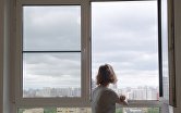 Девушка смотрит в окно в одной из квартир многоэтажного жилого дома по улице Авангардная дом 10 А в Москве, предназначенного для переселения участников программы реновации.