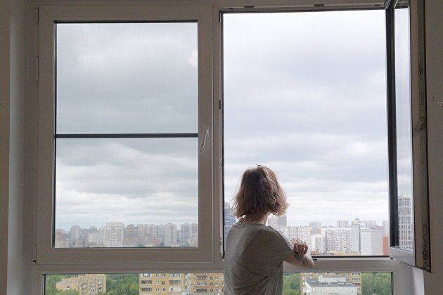 Девушка смотрит в окно в одной из квартир многоэтажного жилого дома по улице Авангардная дом 10 А в Москве, предназначенного для переселения участников программы реновации.