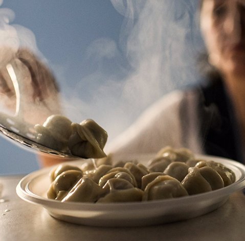 Женщина готовит пельмени в пельменной "Сидоровъ" в Омске