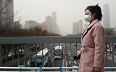 Жительница Пекина в защитной маске во время смога