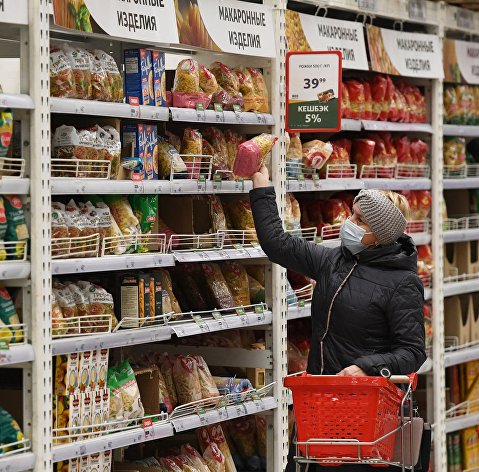 Покупательница выбирает макаронные изделия в гипермаркете "Ашан"