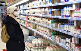 Покупательница выбирает товар в молочном отделе гипермаркета "Ашан"