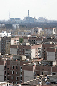 Вид на саркофаг, укрывающий 4-й блок Чернобыльской атомной электростанции. На первом плане - нежилой город Припять.