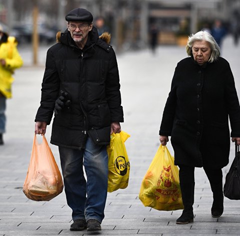 Мужчина с женщиной идут с покупками на Новом Арбате в Москве