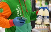 Сборщик заказов "Сбер маркет" собирает заказ в гипермаркете "Ашан" в Новосибирске.