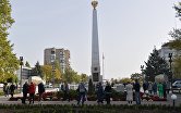 Люди возле стелы "Мелитополь - город воинской славы" на площади Победы в Мелитополе