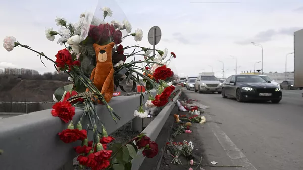 Цветы у стихийного мемориала вдоль дороги у здания концертного зала Крокус Сити Холл