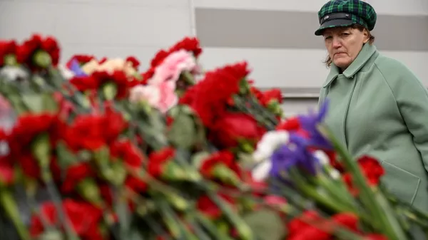 Женщина у стихийного мемориала у здания концертного зала Крокус Сити Холл