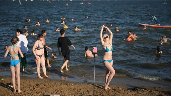 Отдыхающие на пляже Строгинского залива в Москве