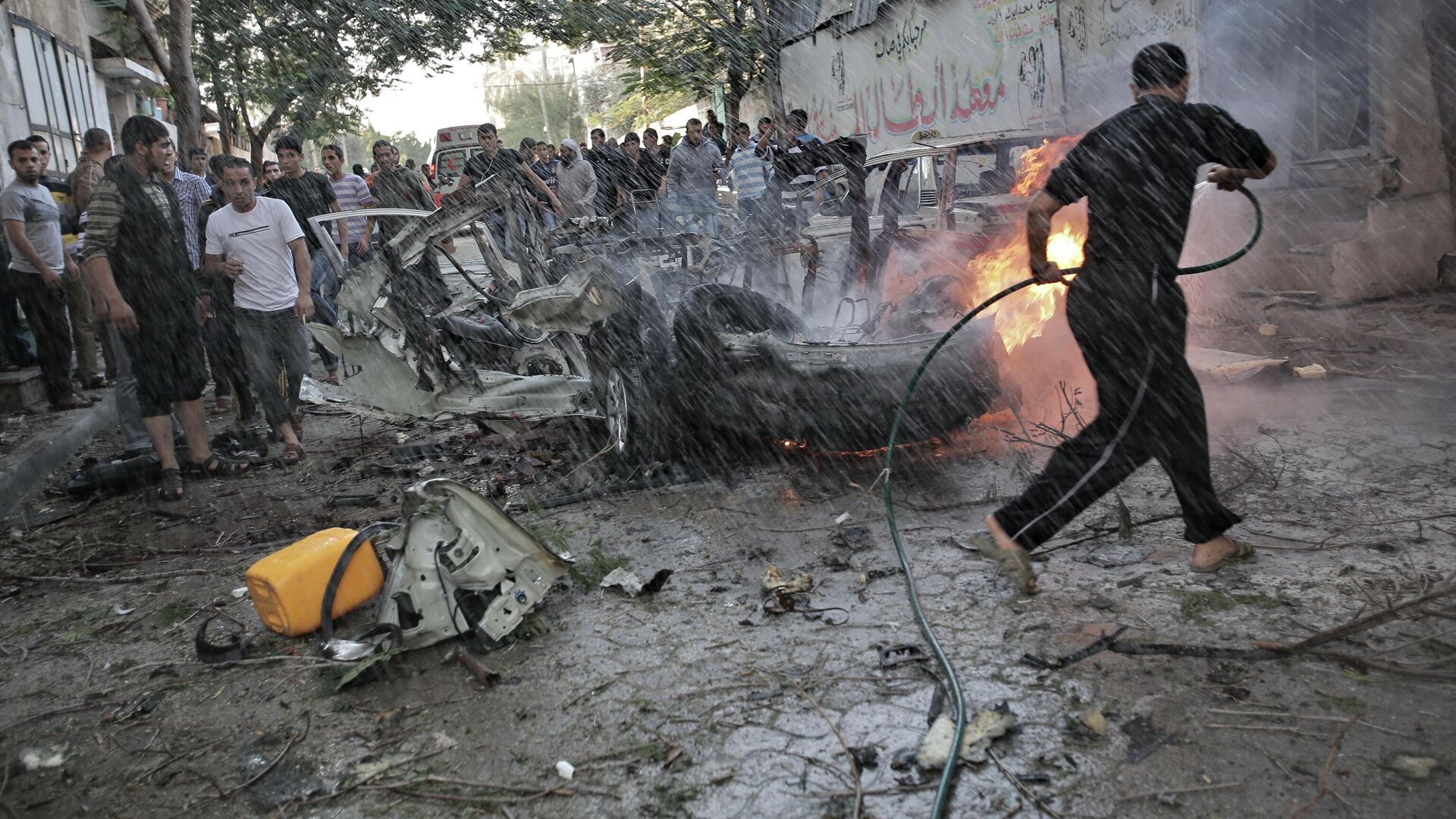 Жители Газы тушат автомобиль, уничтоженный в результате попадания израильской ракеты - ПРАЙМ, 1920, 27.07.2025