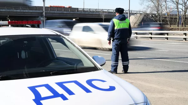 Сотрудник Госавтоинспекции останавливает автомобиль 