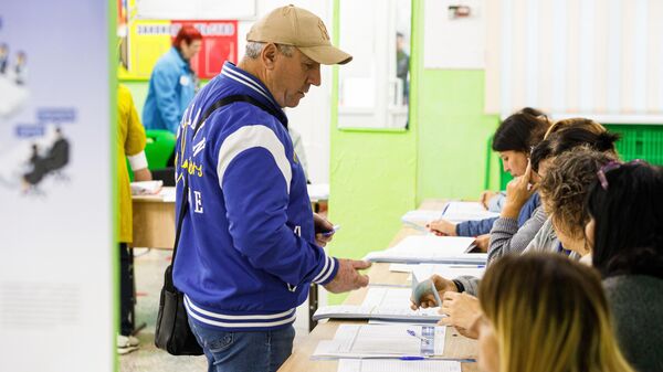 Мужчина голосует на избирательном участке в Кишиневе