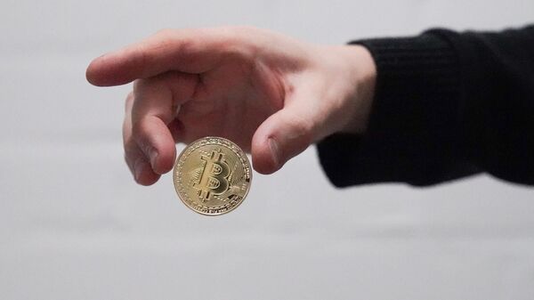 Монета с логотипом криптовалюты биткоин