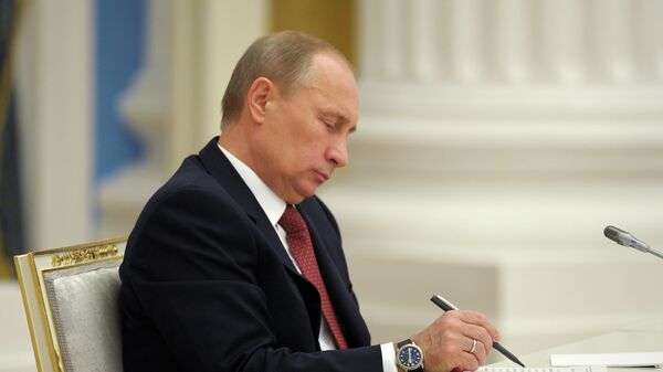 Владимир Путин подписывает документ