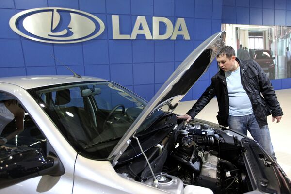 Посетитель осматривает автомобиль Lada Granta