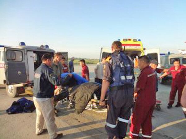 Спасатели МЧС России переносят пострадавших при крушении вертолета Ми-8 в машину скорой помощи
