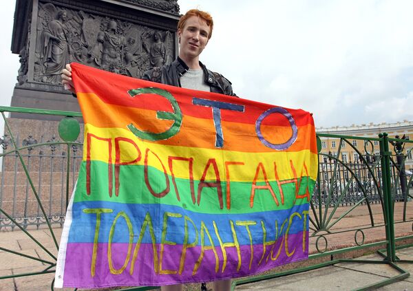 Активист движения ЛГБТ с плакатом: Это пропаганда толерантности во время празднования Дня ВДВ на Дворцовой площади в Санкт-Петербурге