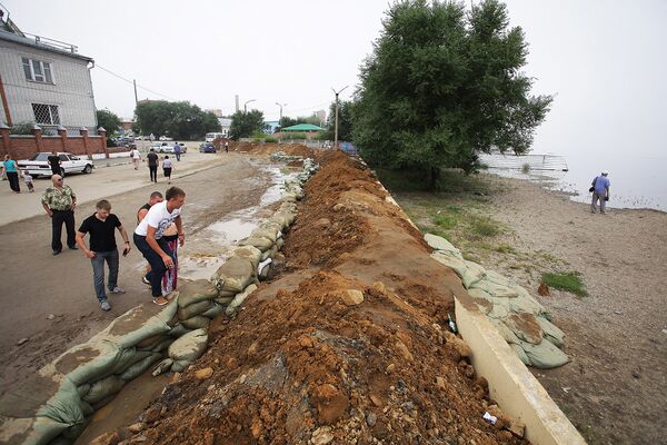 Рабочие возводят песчаный вал на Амуре для защиты города от паводка