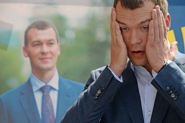 Кандидат в мэры Москвы от ЛДПР Михаил Дегтярев рядом со своим агитационным плакатом