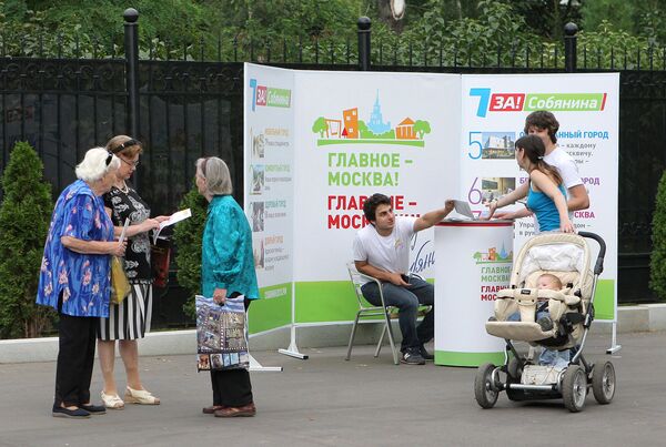 Сотрудник предвыборного штаба кандидата в мэры Москвы Сергея Собянина раздает агитационные материалы посетителям Таганского парка