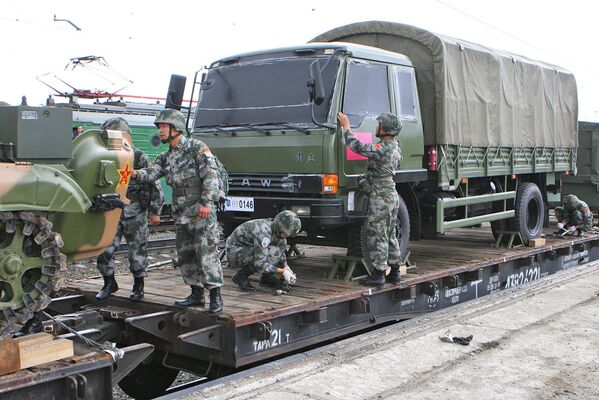 Солдаты сухопутных подразделений армии Китая выгружают военную технику.