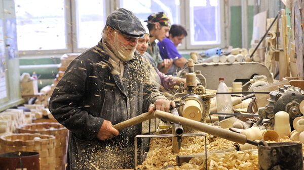 Рабочие токарно-ложкарного цеха вытачивают деревянные изделия для дальнейшей обработки