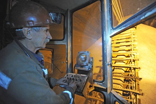 Оператор кратцер-крана работает в подземном складе руды в шахте рудника