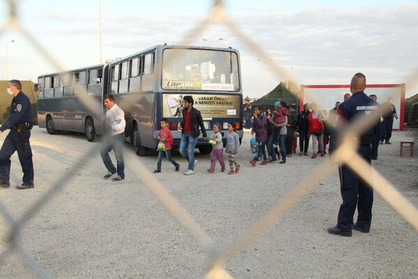 Беженцы заходят в миграционный пункт Реске