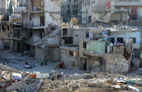 Местные жители на улице среди разрушенных зданий в районе Дахания в Дамаске