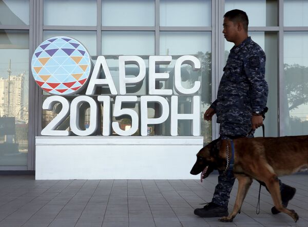 Полицейский идет мимо эмблемы саммита АТЭС в Маниле