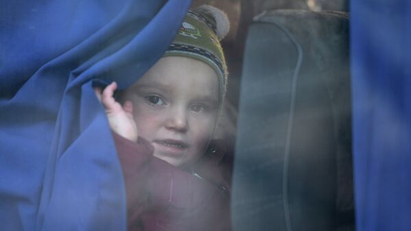 Девочка в автобусе с беженцами, который отправляется из Донецка в Россию