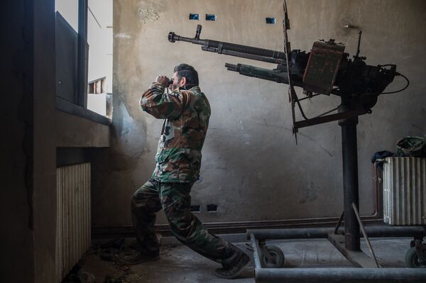 Солдат сирийской армии наблюдает за районом города Хомса Ваер