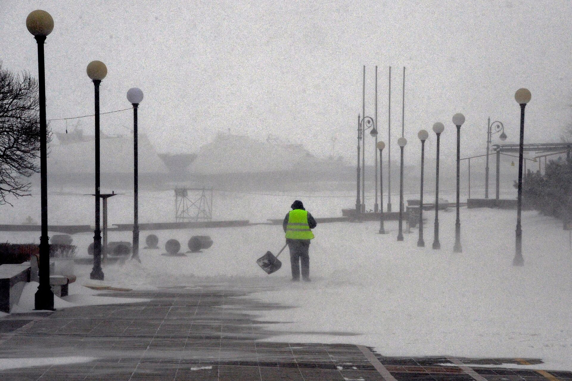 Работник коммунальной службы на набережной Спортивной гавани во время снежного циклона во Владивостоке - ПРАЙМ, 1920, 28.11.2022