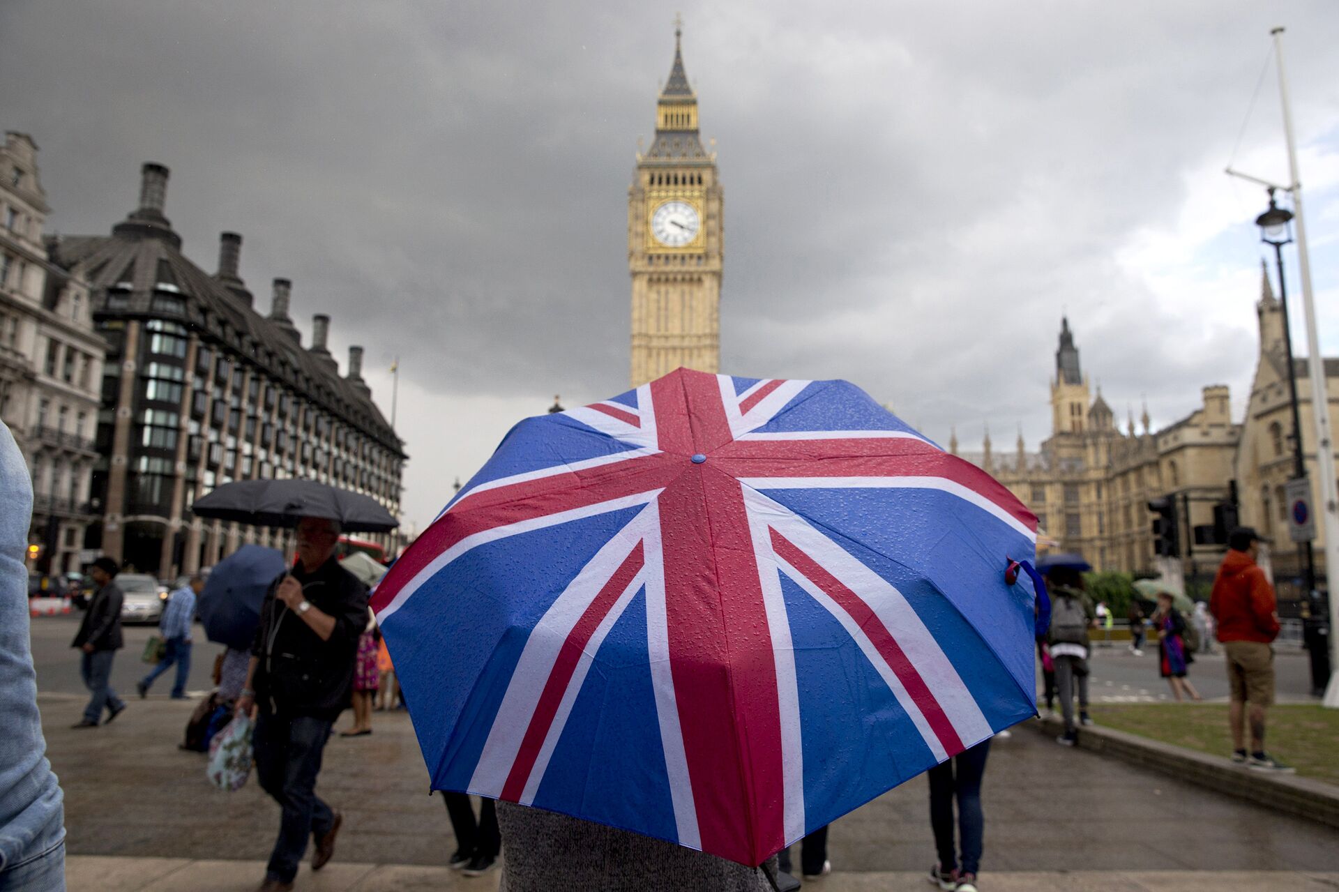 Человек с зонтом с флагом Великобритании у Биг Бена и здания парламента в Лондоне - ПРАЙМ, 1920, 20.12.2020