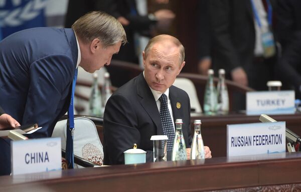 Владимир Путин и помощник президента Юрий Ушаков во время первого рабочего заседания глав делегаций государств-участников Группы двадцати